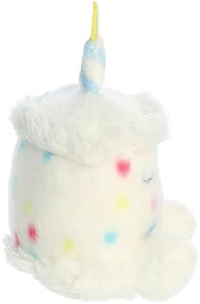 Pocket sized Aurora white birthday cake collectible plush resting in a hand.