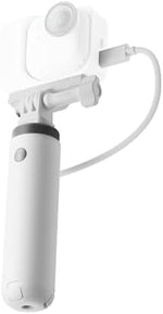 Insta360 action camera battery grip with integrated tripod legs extended on a flat desktop surface.