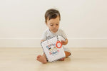 Genius Baby Toys personalizable infant photo book with family pictures inserted in the slots.