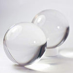 Two transparent fifty millimeter juggling spheres held in a hand for scale references