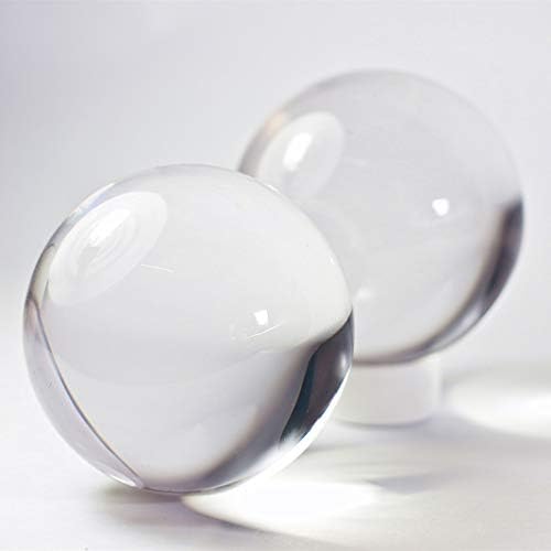 Two transparent fifty millimeter juggling spheres held in a hand for scale references