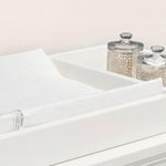 White Delta Children changing pad with contoured safety sides