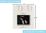 Wooden baby ultrasound keepsake frame displayed on a modern nursery room shelf.