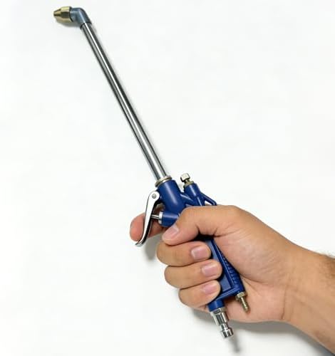 Mechanic using pneumatic oil siphon tool to clean grease from industrial machinery