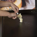 Applying premium Blackstone griddle conditioner on a warm iron cooktop