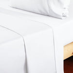 Side view of the single piece white queen size flat sheet draped elegantly