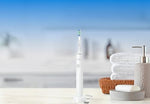 Philips Sonicare rechargeable toothbrush placed next to its protective white Smoocu travel case on a bathroom counter.