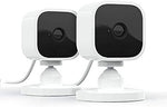 Two pack bundle of Amazon Blink Mini security cameras positioned on a flat table to highlight their compact size.