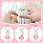 Close up view of the hypoallergenic cream-colored crochet rabbit doll detailing the pink bow and knitted texture.
