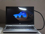 i2 Gear portable keyboard lamp plugged into a standard laptop computer port providing workspace illumination.