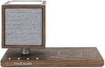 Tivoli Audio Revive wireless charging pad base with a smartphone receiving an induction charge.