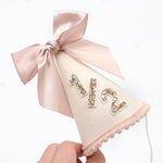 Pink satin bow and pom-pom trim on Lingana princess cone hat