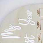 Haoser rustic neutral wood milestone photo board placed on a tabletop easel layout.