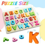 Close up of a child hand holding a bright red wooden letter piece from the Jolsnaf ABC puzzle set.