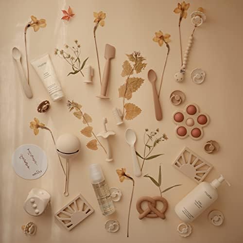 Waterproof and stain resistant Mushie silicone dummy holder being washed with soap