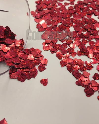 Hand holding glitter heart confetti for photo shoot backdrop
