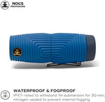 Durable and shockproof blue monocular being held comfortably in an adult hand to demonstrate its lightweight travel size.