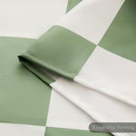 Machine washable green check pattern shower curtain being unfolded fresh and clean after a quick laundry wash.
