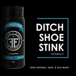 Travel size shoe freshener bottle being squeezed into a pair of athletic sneakers.