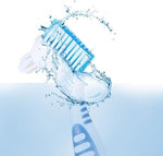 Side view of dual head denture brush illustrating the angled tapered tuft for crevices