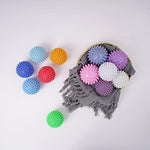 Set of four random color laundry balls for lint and pet hair removal.
