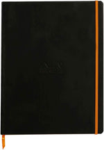 Rhodia black flexible notebook front view showing soft faux leather cover and orange elastic band.