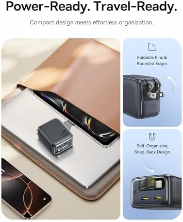 Baseus retractable cord travel adapter sitting next to a mobile phone and a laptop computer