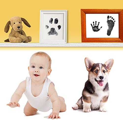 Completed baby handprint and dog paw print artwork inside a nursery picture frame.