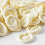 White disposable 4 Mil thick finger sleeves spread out on a clean workbench