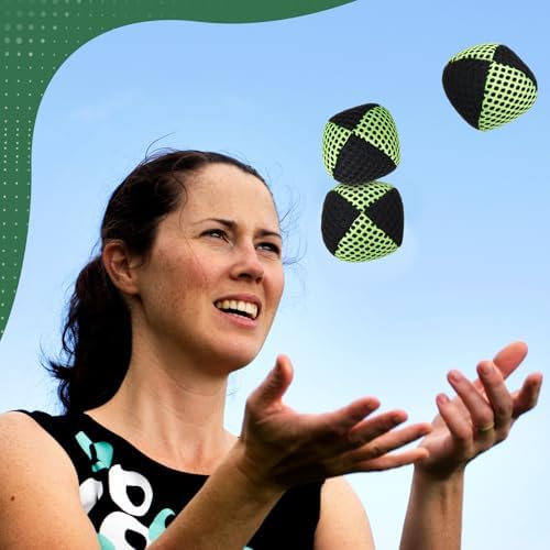 Person practicing with Soulchen black and green juggling balls outdoors