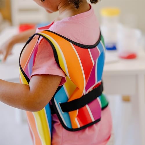 Child writing their name with a dry erase marker on the personalizable pocket of the Melissa and Doug art smock.