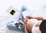 Boom Moments pregnancy announcement frame being held to showcase the three by four inch photo opening.