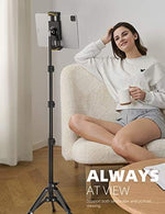 Lamicall height adjustable floor mount fully extended to sixty-five inches next to a standing person.