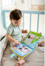 Soft fabric baby book opened to reveal clear photo insert pockets