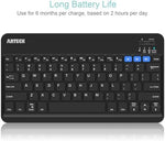 Arteck rechargeable universal keyboard close up on chiclet keys with bright blue LED backlight activated.