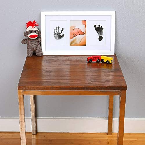 Solid wood baby keepsake frame with UV protection glass showcasing an infant photo and handprint stamp.