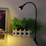 Tyenaza portable desk light plugged into a laptop USB port illuminating the keyboard