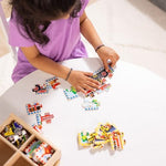 Toddler using the sliding wooden box lid as an assembly board for the fire engine puzzle