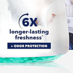 Hand pouring Downy Cool Cotton beads into a washing machine drum for laundry freshness.
