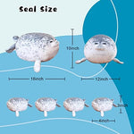 Four small baby seal plushies lined up next to the large gray TOYSYM mommy seal pillow.