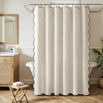 Close up view of the black trim and scalloped edge detail on the beige cloth curtain