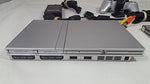 Imported Sony PlayStation 2 controller in silver showing twin thumbsticks and analog buttons.