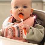 Assorted vibrant colors of Nuby long handle infant spoons displayed together.