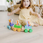 Six piece wooden animal train playset unboxed demonstrating how characters fit snugly inside the rolling train compartments.