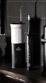 GOSS rechargeable automatic toothbrush being placed inside the protective ultraviolet sanitizing case for travel.