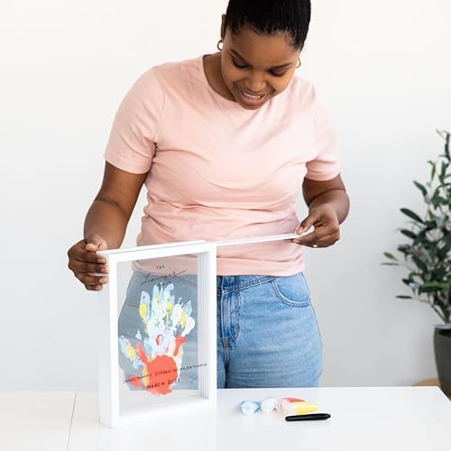 Three dimensional layered family handprint artwork inside the sleek white Pearhead home decor frame.