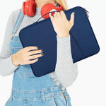 CAAORDKSO slim lightweight laptop sleeve being inserted smoothly into a large travel backpack.