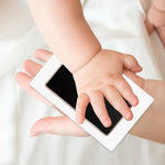Demonstration of a newborn baby foot pressing onto the safe inkless print stamp pad kit.