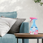 Using Febreze fabric spray on household textiles for a fresh laundry scent.