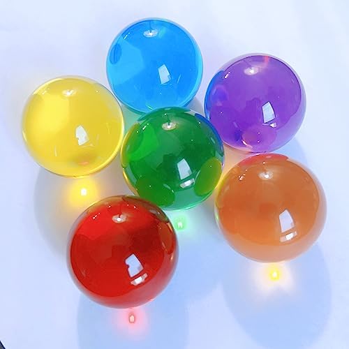 Side angle view of three pack of DSJUGGLING one and a half inch plastic resin balls showing glass like transparency